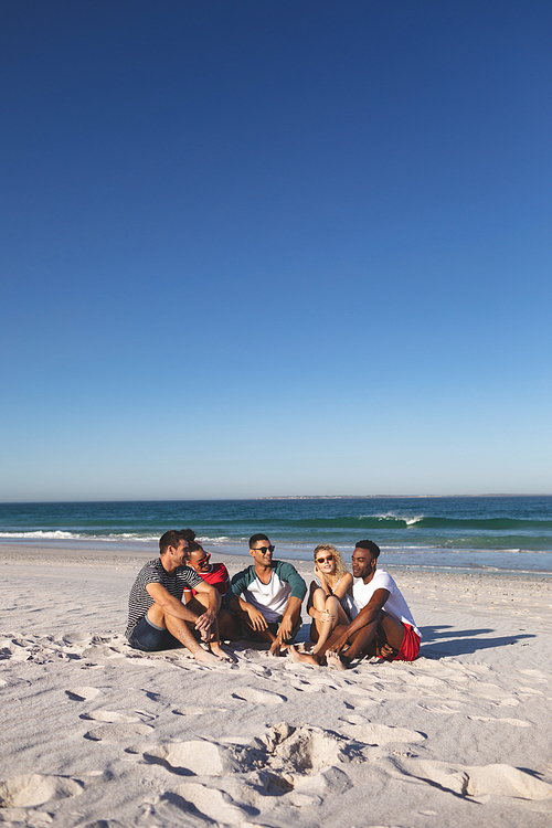 Front view of group of happy diverse friends having fun together on the beach