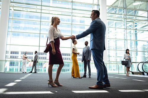 Side view Caucasian diverse executives shaking hands in modern office