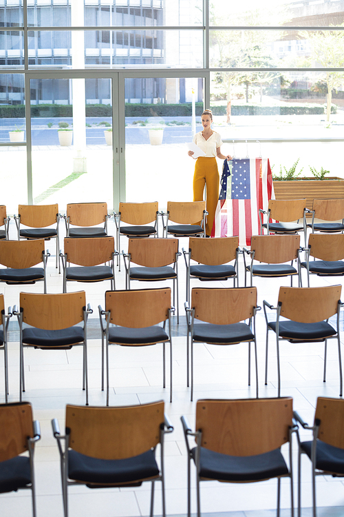 Front view of young Caucasian female executive looking at digital tablet in empty conference room