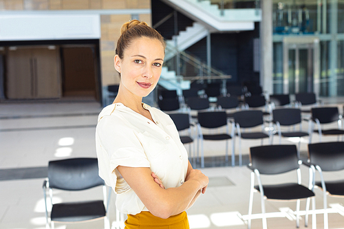 Front view of young Caucasian female executive  while standing in empty conference room