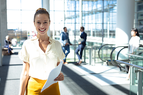 Front view of young Caucasian female executive  while walking in modern office