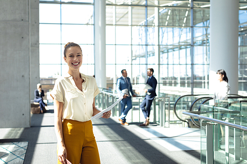 Front view of young Caucasian female executive  while walking in modern office