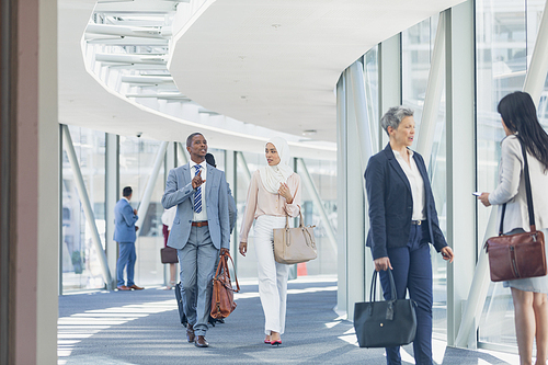 Side view of businesswomen interacting with each other in corridor in modern office