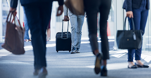 Low section of diverse business people walking in corridor in modern office