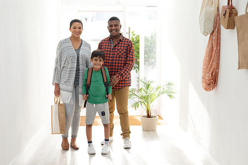 Portrait of mixed race family standing together near door at home