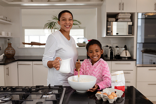Front view of African american Mother and daughter preparing food on a worktop in kitchen at home