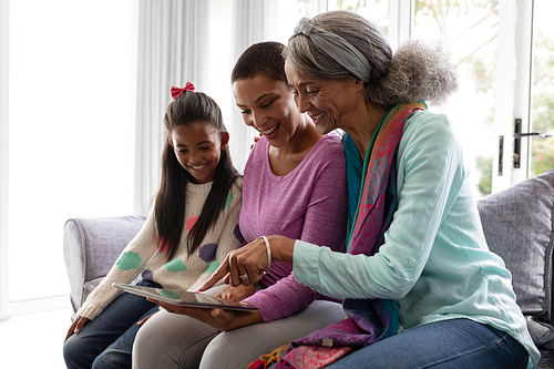 Portrait of African american Multi-generation family using digital tablet on a sofa in living room at home