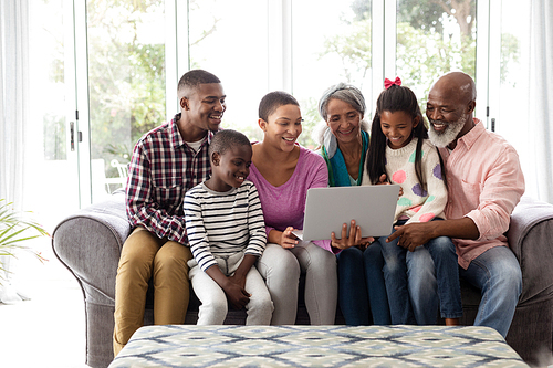 Front view of African american Multi-generation family using laptop on a sofa in living room at home