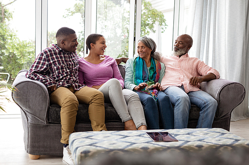 Front view of African american Family interacting with each other on a sofa in living room at home