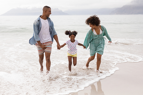 Front view of Happy African american family having fun together on the beach