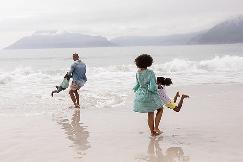 Side view of Happy African american family having fun together on the beach
