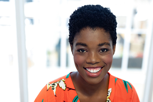 Portrait of pretty young African american female graphic designer smiling in office. This is a casual creative start-up business office for a diverse team