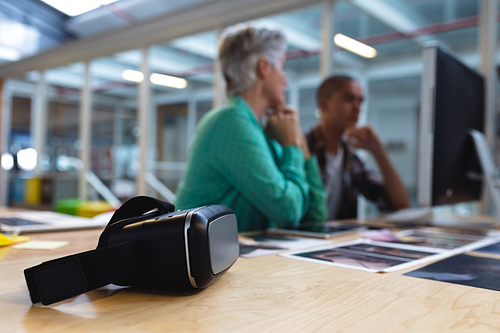 Close-up of virtual reality headset on a desk in office. This is a casual creative start-up business office for a diverse team