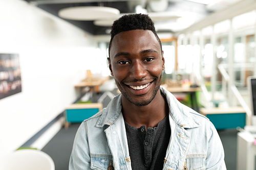 Portrait of African american male graphic designer smiling in office. This is a casual creative start-up business office for a diverse team