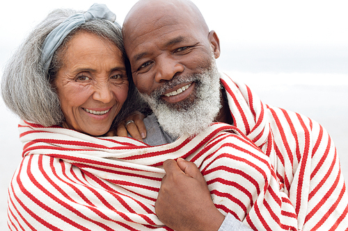 Front view of happy senior diverse Couple smiling at the beach. Authentic Senior Retired Life Concept