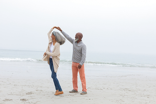 Front view of happy senior diverse Couple smiling at the beach. Authentic Senior Retired Life Concept