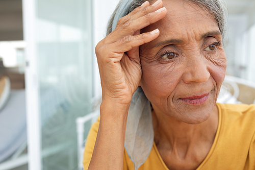 Front view of African American Woman inside a room with hand on the forehead. Authentic Senior Retired Life Concept