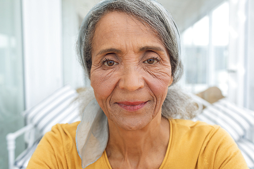 Front view of African American Woman inside a room smiling. Authentic Senior Retired Life Concept