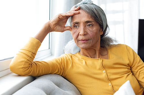 Front view of African American Woman inside a room thinking. Authentic Senior Retired Life Concept