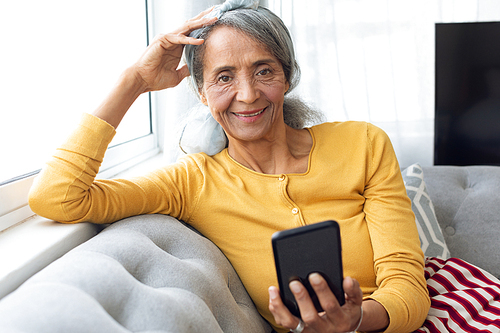 Front view of African American Woman using smartphone. Authentic Senior Retired Life Concept