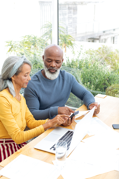 Side view of African American Couple calculating finances. Authentic Senior Retired Life Concept