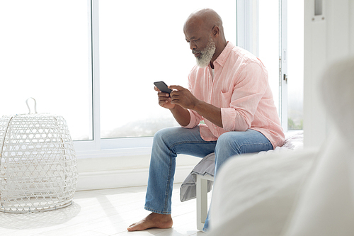 Side view of African American Thoughtful man using smartphone. Authentic Senior Retired Life Concept