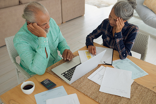 Aerial view of concerned African-American couple doing finances on the table indoor. Authentic Senior Retired Life Concept