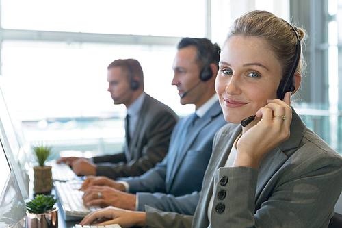 Close-up of Businesswoman talking on headset at desk in office. Modern corporate start up new business concept with entrepreneur working hard