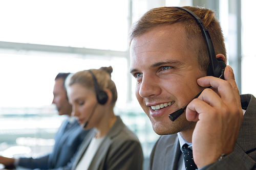 Close-up of Businessman with his colleagues talking on headset in office. Modern corporate start up new business concept with entrepreneur working hard