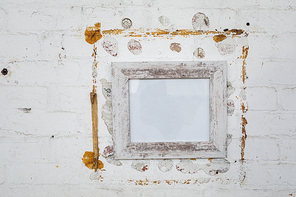 Close up of a framed blank picture hanging on a white brick wall