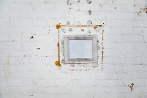 Close up of a framed blank picture hanging on a white brick wall