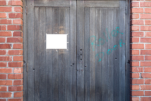 A blank sign hanging on a wooden door