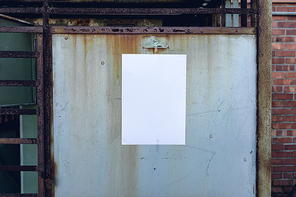 Close up of a blank sign hanging on a metal door