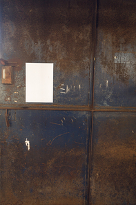 Close up of a blank sign hanging on a metal door