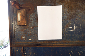 Close up of a blank sign hanging on a metal door