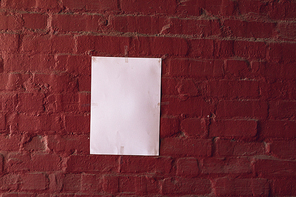 Close up of a blank sign hanging on a red brick wall