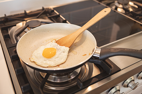 Close up view of a fired egg on pan in a bright kitchen interior. Self isolating and social distancing in quarantine lockdown during coronavirus covid 19 epidemic.