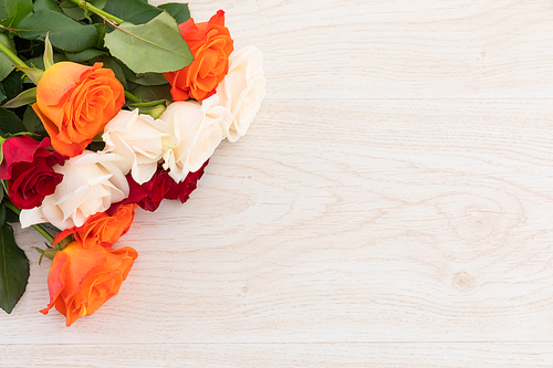 Bunch of orange, white and red roses on wooden background. flower spring summer nature freshness copy space.