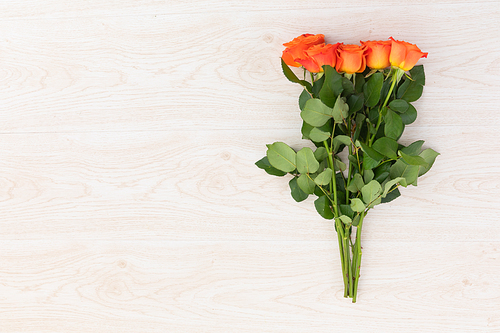 Bunch of orange roses lying on wooden background. flower spring summer nature freshness copy space.