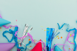 Party hat, party blowers and confetti on blue background. happy birthday party celebration fun concept.