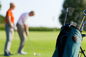 Mature or senior couple playing golf|FOCUS IS ON BAG IN FRONT