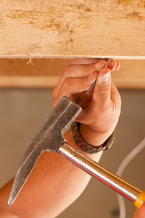 Construction worker _x0013_ only hand to be seen - with hammer and nail