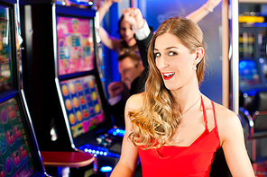 Friends in Casino on a slot machine; a woman is looking into the camera