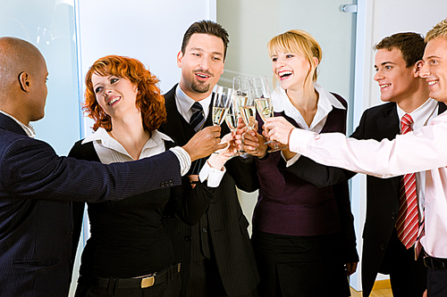 People at a reception at the point where the toast is being given|maybe an office party - people wearing business clothes