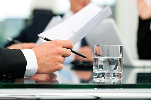 Business - meeting in an office; lawyers or attorneys discussing a document or contract agreement