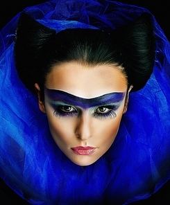 Wonderful young woman with beautiful creative makeup on her face looks like bat . Studio shot close up