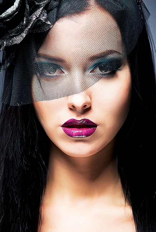 Close-up portrait of a young sad woman with black mourning veil