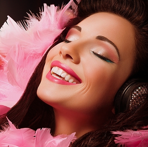 Inspiration. Fancy Cheerful and Happy Woman with pink Feathers smiling. Pleasure
