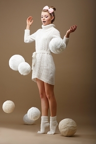Falling Skeins. Surprised Woman in Woolen Knitted Jersey with White Balls of Yarn