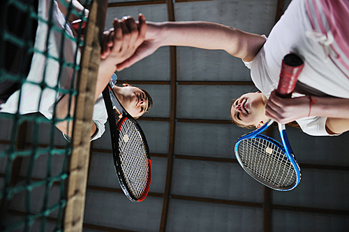 young girls playing tennis game indoori in tennis court